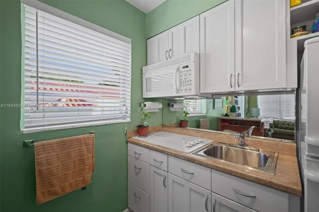a kitchen with stainless steel appliances granite countertop a sink and a white cabinets