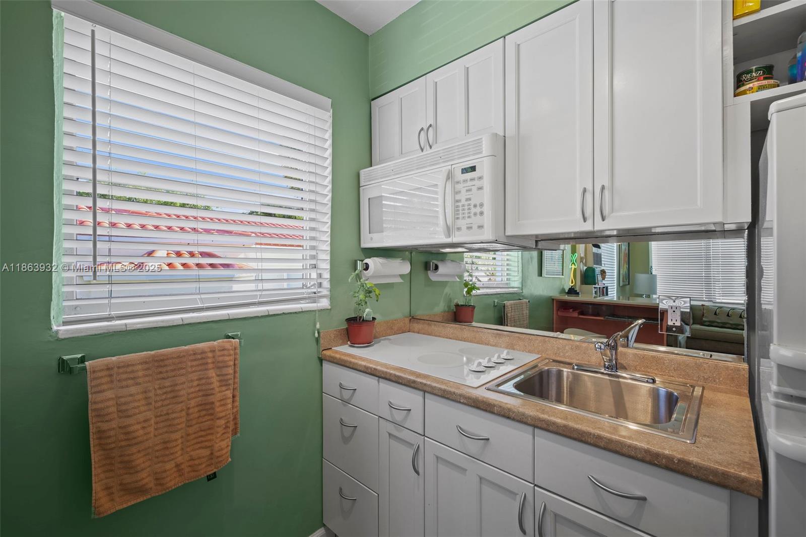 1525 Meridian Avenue, Unit 202 Miami Beach, FL 33139 - Photo 10 of 23 a kitchen with stainless steel appliances granite countertop a sink and a white cabinets