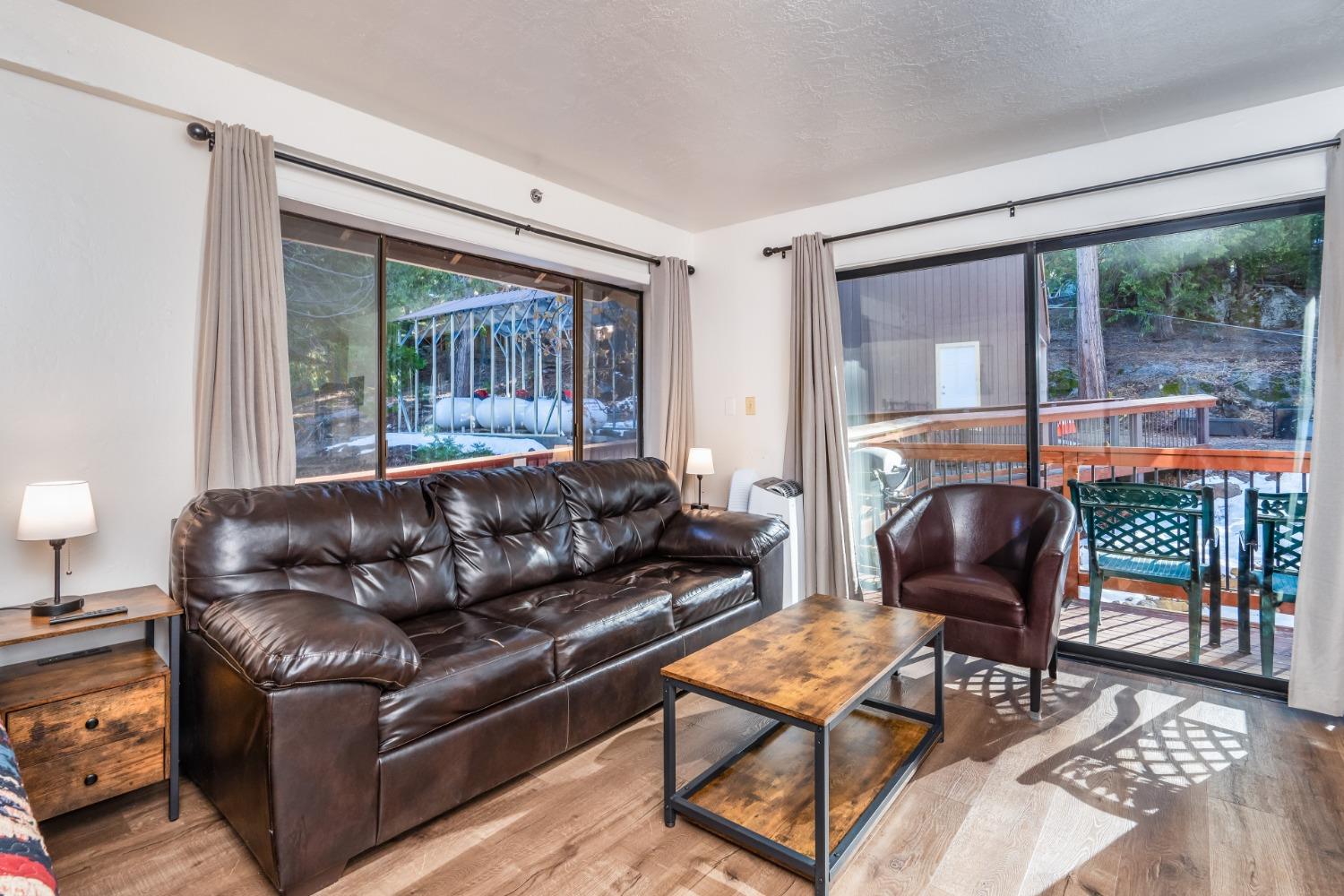 7540 Henness Circle, Unit B101 Yosemite West, CA 95389 - Photo 2 of 20 a living room with furniture and a floor to ceiling window