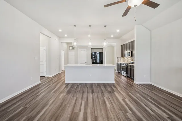 a large white kitchen with wooden floors and a fireplace