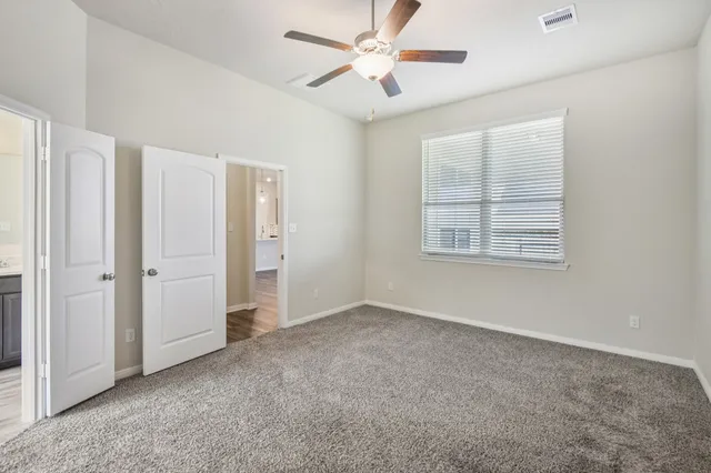 an empty room with closet and a ceiling fan