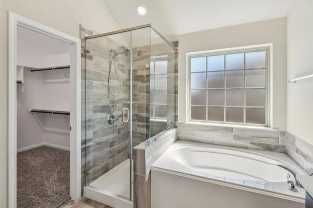 a bathroom with a tub sink and mirror