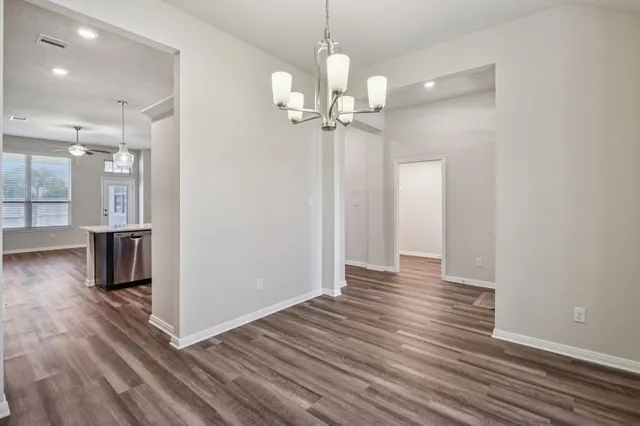 a view of a room with wooden floor staircase and a kitchen space