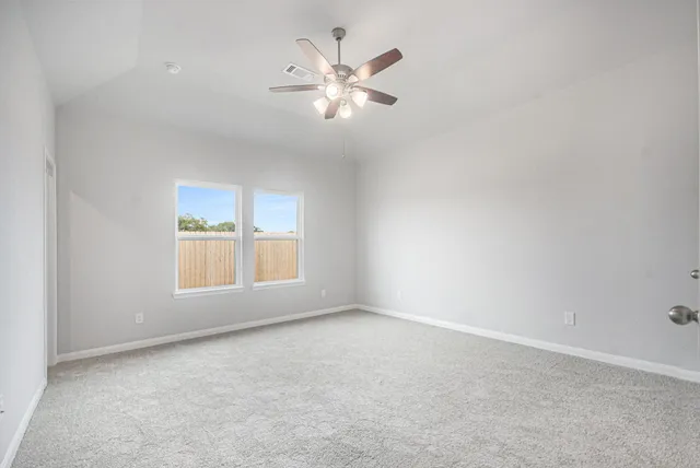 an empty room with closet and a ceiling fan