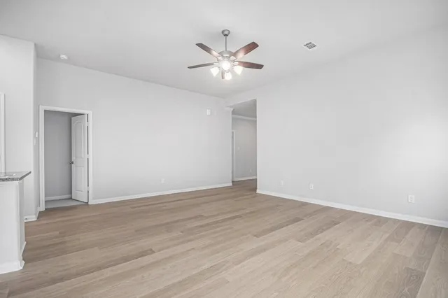 a view of an empty room with wooden floor