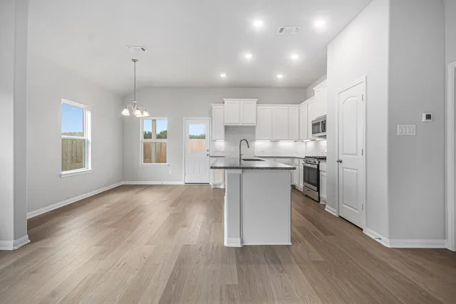 a view of kitchen with kitchen island and stainless steel appliances