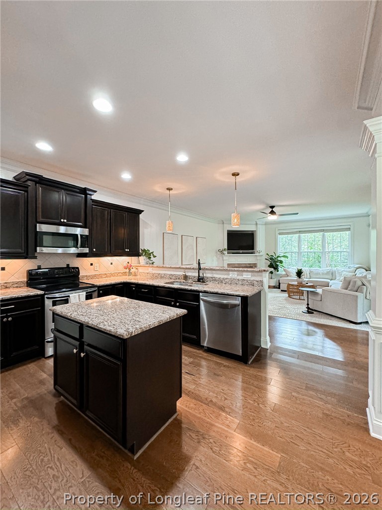 93 Falcon Ridge Drive Spring Lake, NC 28390 - Photo 14 of 50 a kitchen with stainless steel appliances kitchen island granite countertop a stove top oven a sink a counter top space and cabinets