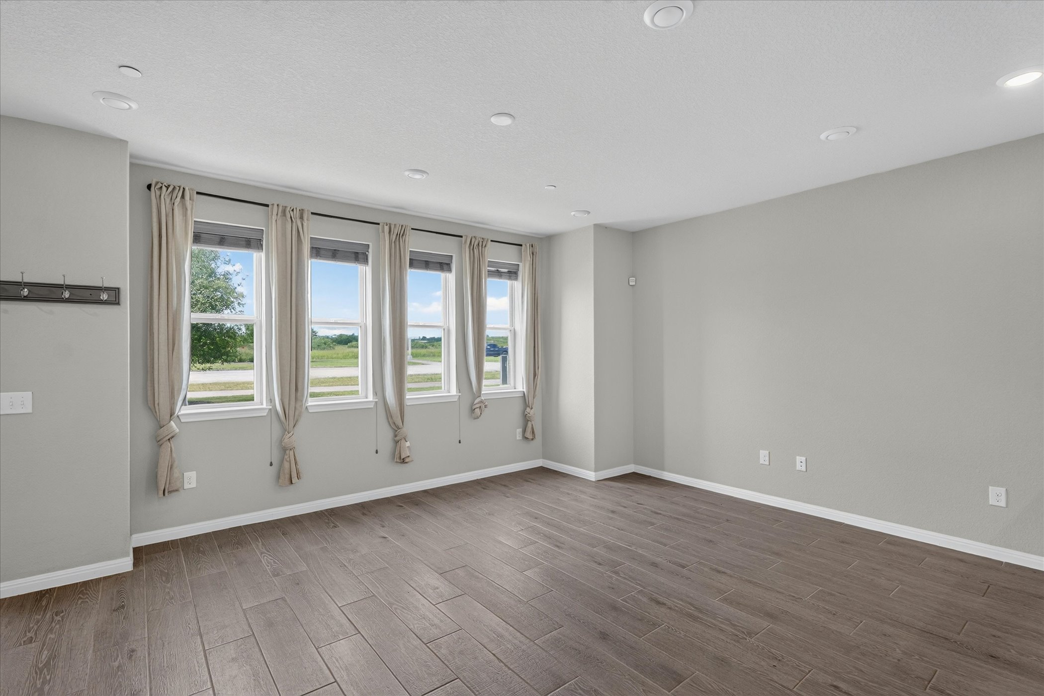 9015 Cattle Baron Path, Unit 1102 Austin, TX 78747 - Photo 4 of 25 Recessed lighting illuminates wood-look tile flooring in this inviting open space.
