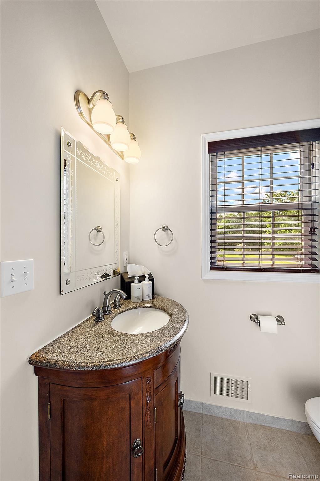 5035 Hidden Ridge Road Metamora, MI 48455 - Photo 25 of 65 Bathroom featuring a dark wood vanity with a granite countertop and an undermount sink