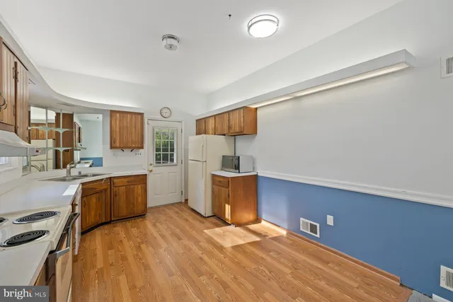 a kitchen with a wooden floor and window