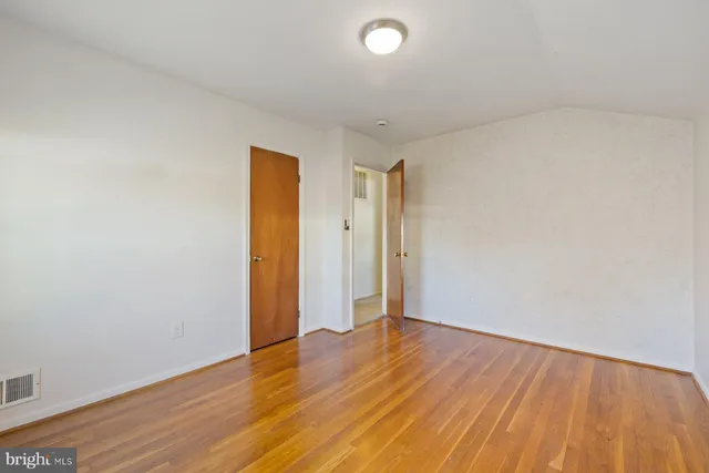 an empty room with wooden floor and closet