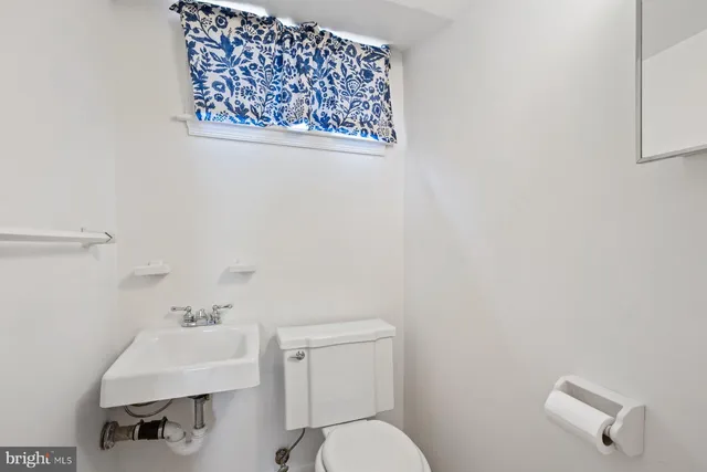 a bathroom with a sink mirror and toilet