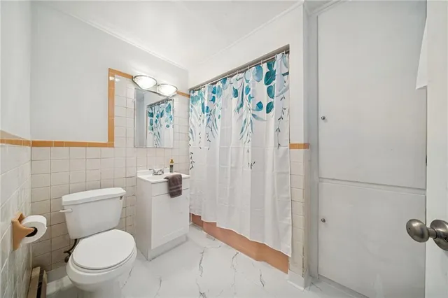 a white toilet sitting next to a shower curtain