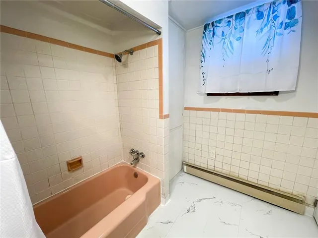 a bathroom with a tub and shower
