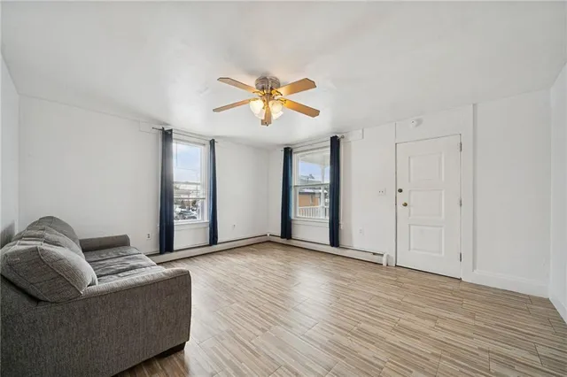 a living room with furniture and a ceiling fan
