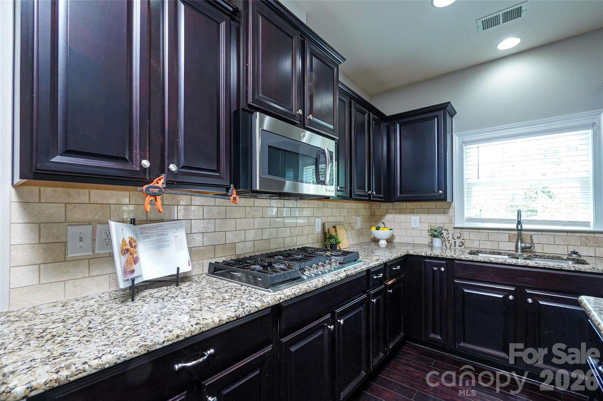 4008 Oxford Mill Road Waxhaw, NC 28173 - Photo 14 of 44 a kitchen with granite countertop stainless steel appliances a sink stove and microwave