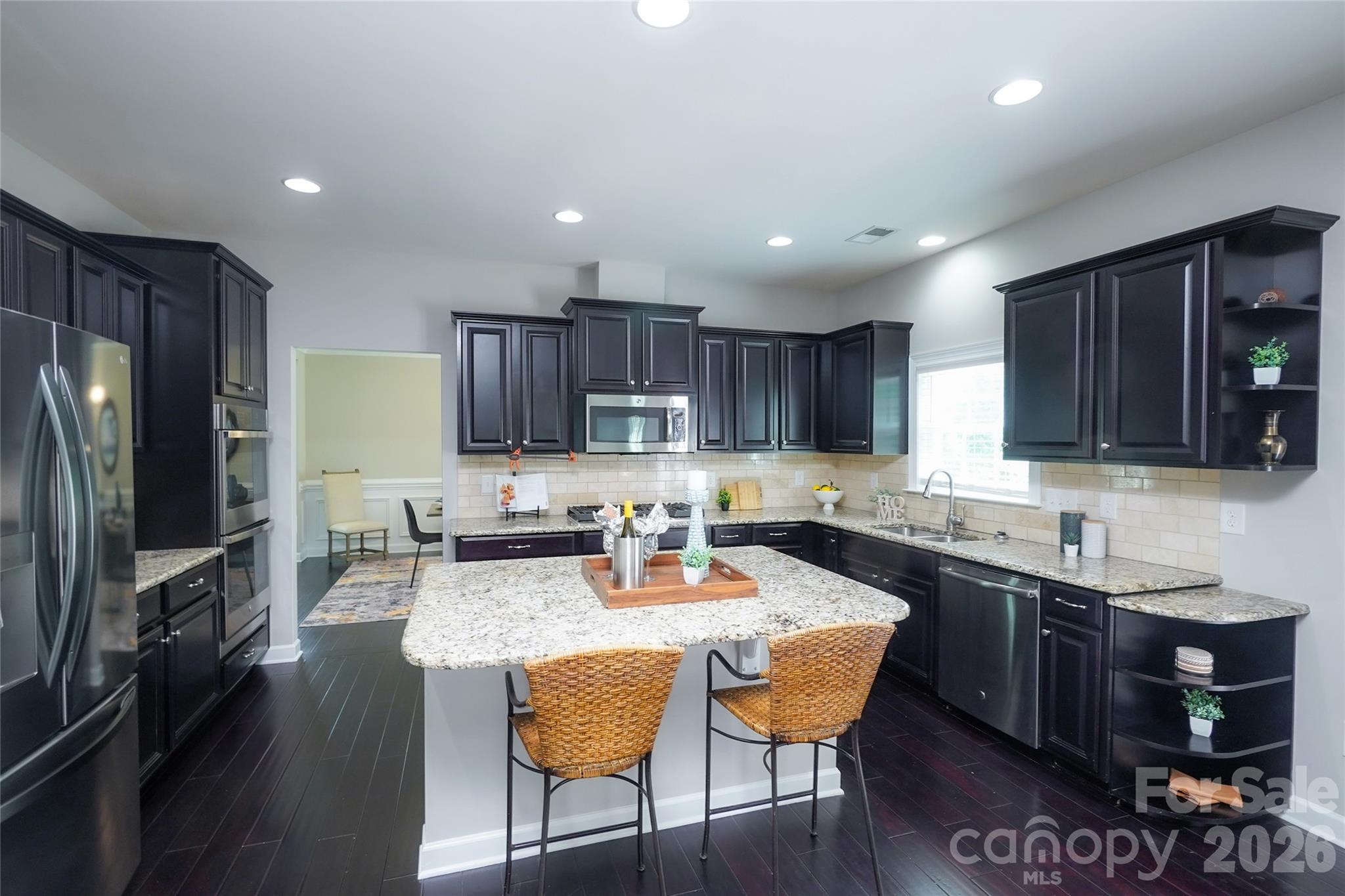 4008 Oxford Mill Road Waxhaw, NC 28173 - Photo 16 of 44 a kitchen with granite countertop a dining table and chairs