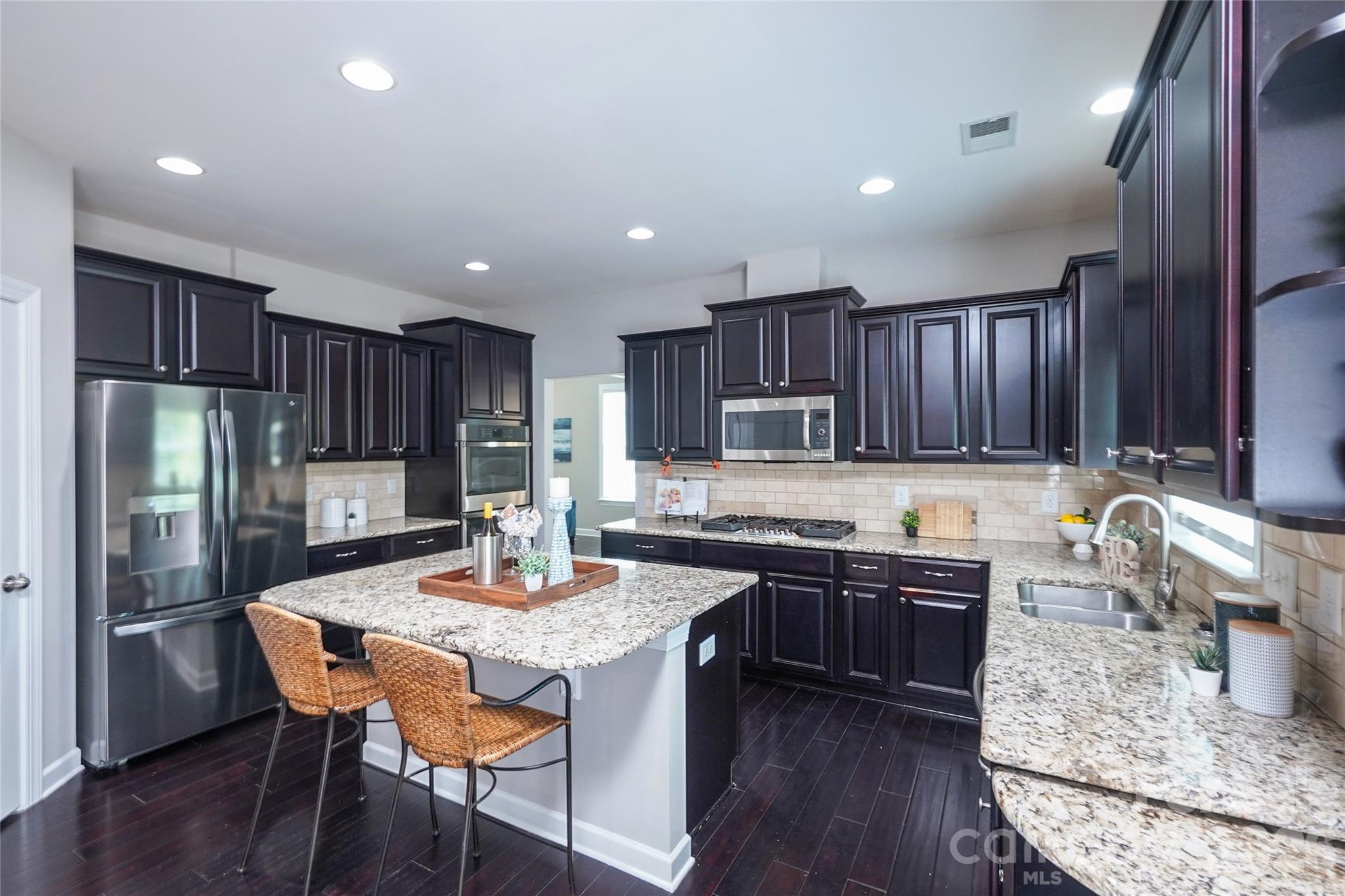 4008 Oxford Mill Road Waxhaw, NC 28173 - Photo 17 of 44 a kitchen with granite countertop a sink stove and refrigerator