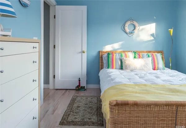 a bedroom with a bed and painting on the wall