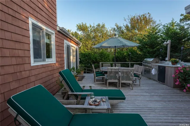 an outdoor sitting area with furniture and umbrella