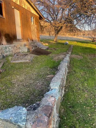 a view of a yard with an tree and a wooden fence