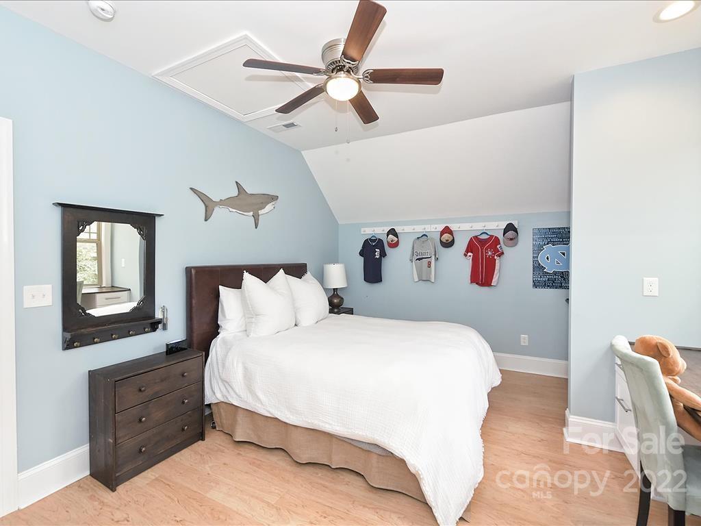 801 Sedgefield Road Charlotte, NC 28209 - Photo 24 of 30 a bedroom with a large bed and a chandelier