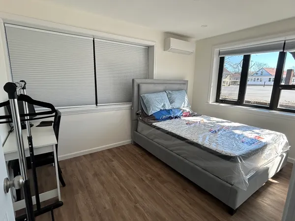 a bedroom with a bed and wooden floor