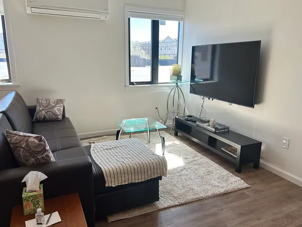 a bedroom with bed couch and window