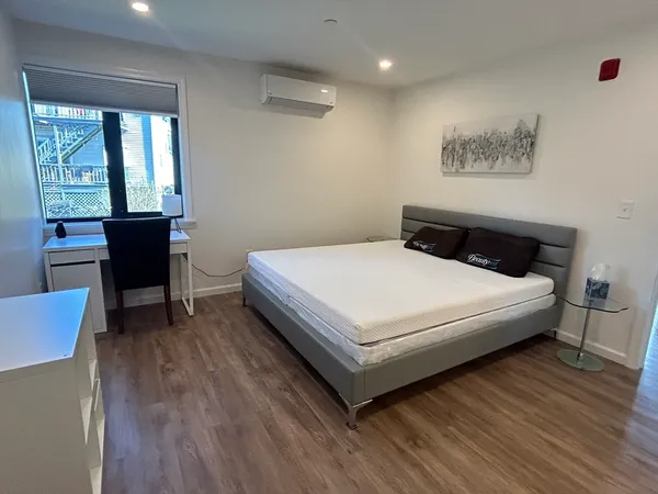 a white bed sitting in a bedroom next to a window