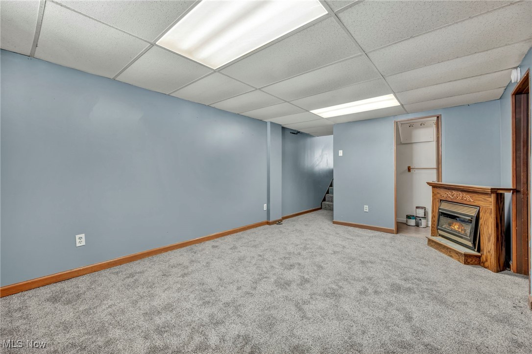 2514 Primewood Road Akron, OH 44305 - Photo 32 of 49 Finished below grade area with stairway, a glass covered fireplace, carpet flooring, and a drop ceiling