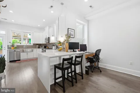 a kitchen with a table chairs microwave and cabinets