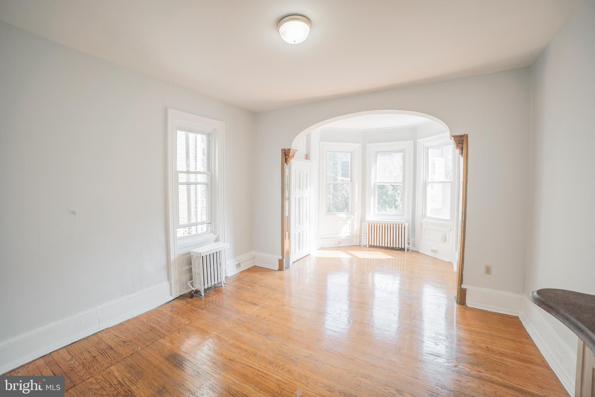 2316 Spruce Street, Unit 2R Philadelphia, PA 19103 - Photo 3 of 11 an empty room with wooden floor and windows