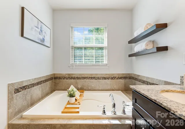 a bathroom with a granite countertop tub and a sink