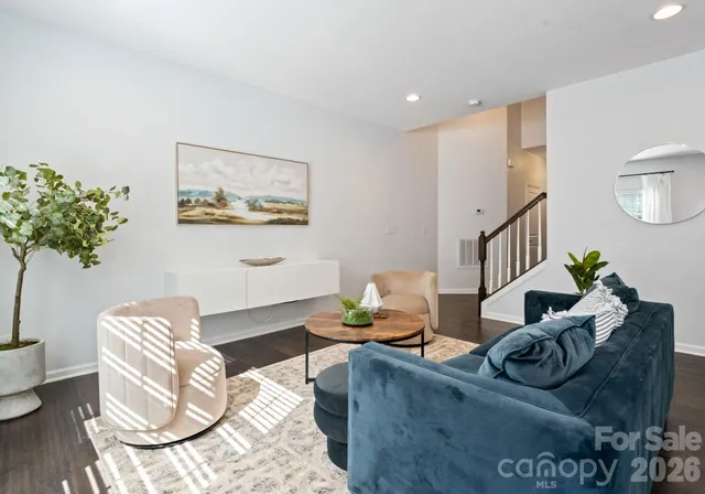 a living room with furniture flowerpot and wooden floor