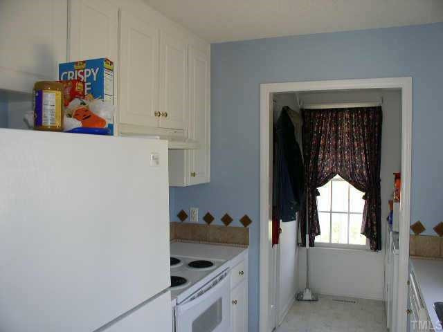 145 Ridge Way Lane Clayton, NC 27520 - Photo 2 of 8 Kitchen with decorative tile backsplash. Refrigerator stays. Pantry and Laundry Room open to kitchen. Washer and Dryer stay. Other