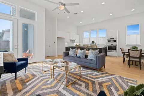 a living room with furniture and a dining table with kitchen view