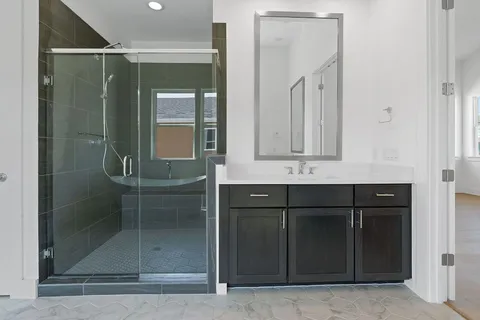a bathroom with a shower sink and mirror
