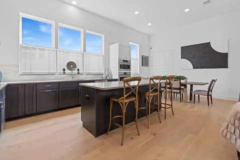 a kitchen with cabinets a sink table and chairs