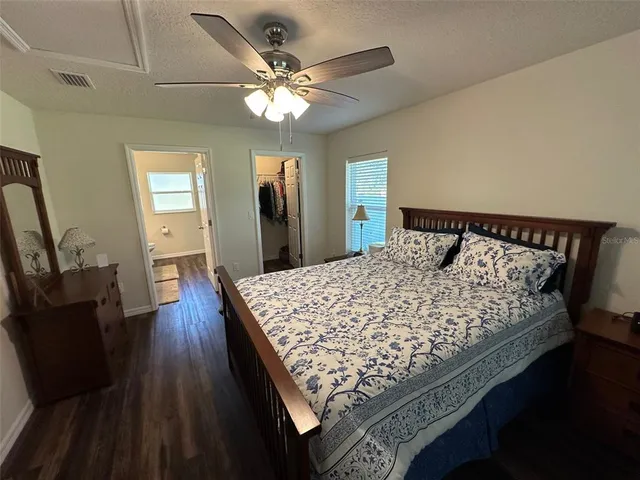 a bed sitting in a bedroom next to a large mirror with wooden floor