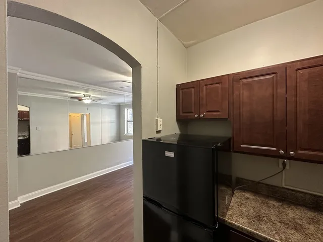 a kitchen with a wooden floor and cabinets