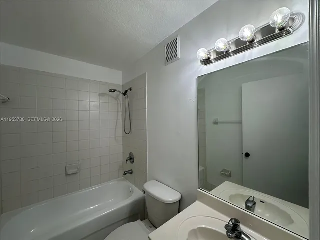 a bathroom with a toilet a sink and shower