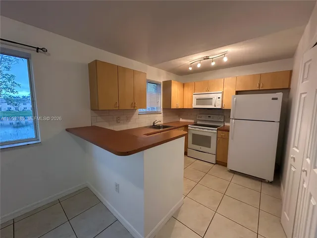a kitchen with a refrigerator sink and microwave