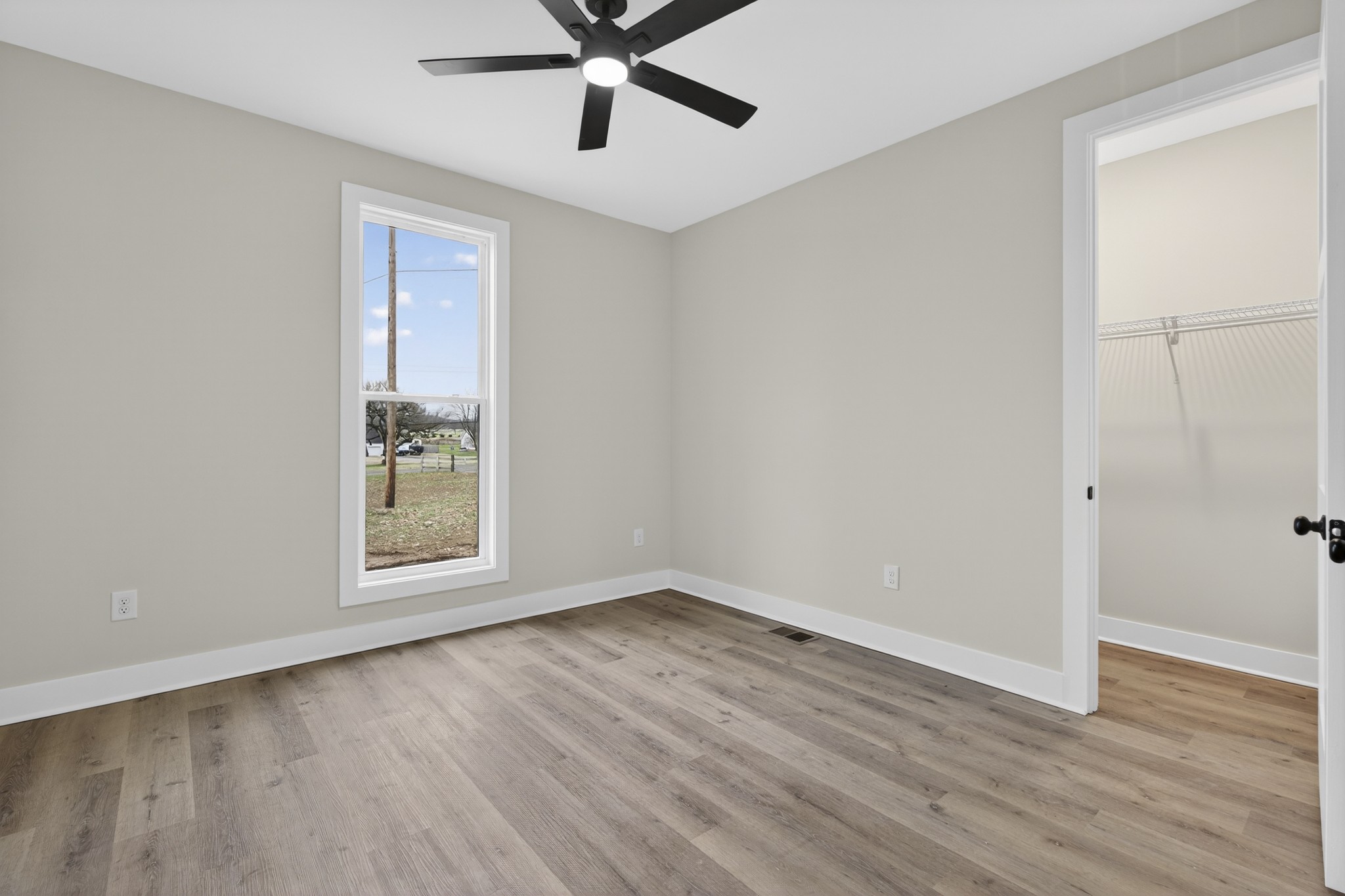 777 Rock Springs Road Castalian Springs, TN 37031 - Photo 14 of 56 an empty room with wooden floor fan and windows