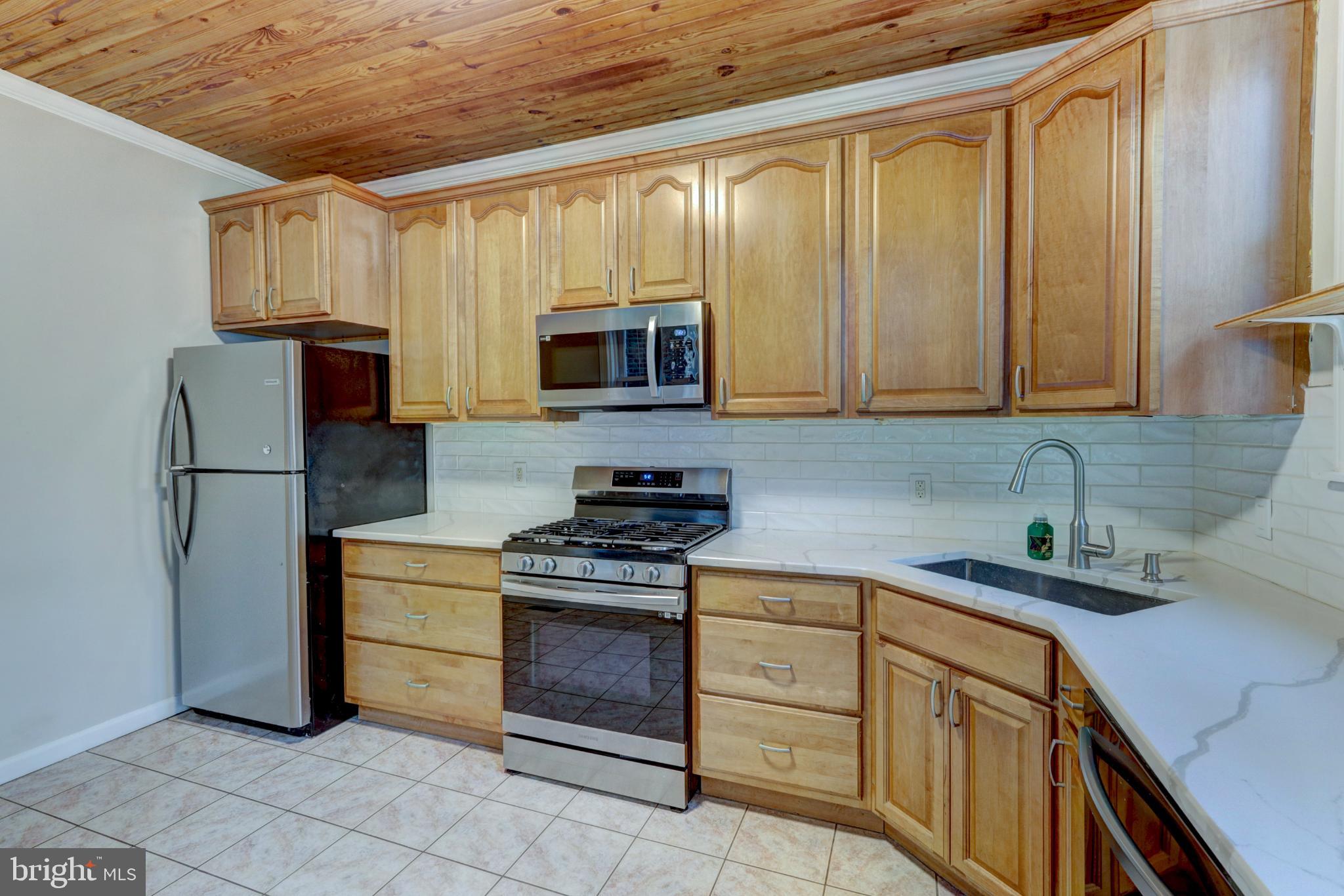 112 Vassar Street Philadelphia, PA 19128 - Photo 13 of 33 a kitchen with stainless steel appliances granite countertop a refrigerator stove and sink