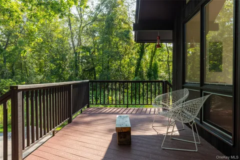 a patio with wooden floor table and chairs
