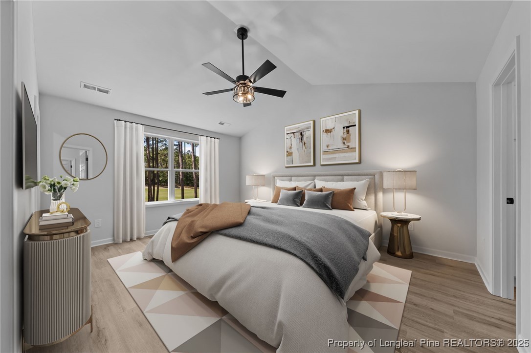 15880 Fox Lane Wagram, NC 28396 - Photo 15 of 33 a bedroom with a large bed and a chandelier