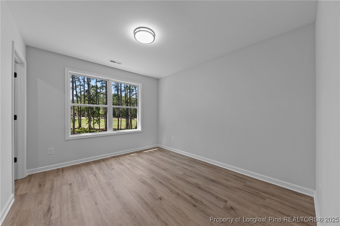 15880 Fox Lane Wagram, NC 28396 - Photo 23 of 33 an empty room with wooden floor and windows