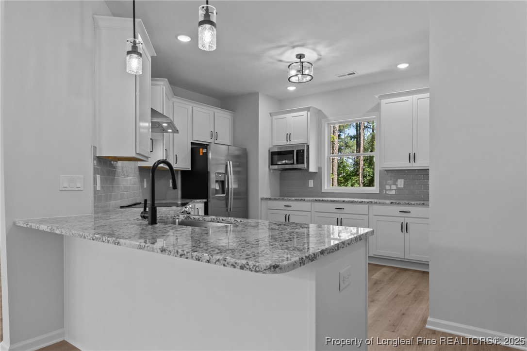 15880 Fox Lane Wagram, NC 28396 - Photo 10 of 33 a kitchen with kitchen island granite countertop a sink cabinets and window