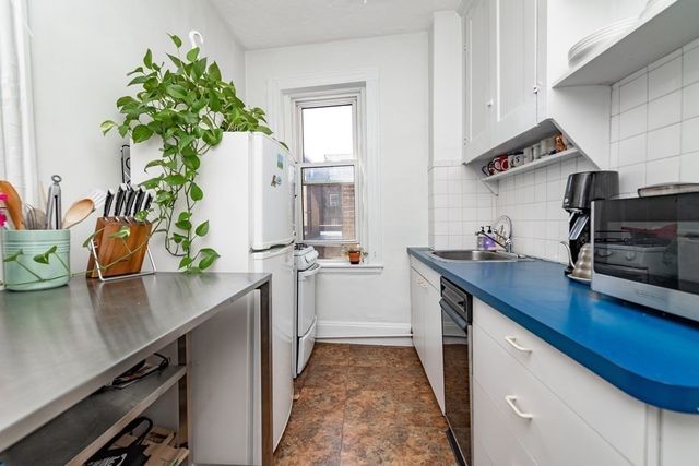 a kitchen with stainless steel appliances a sink a stove and a wooden floor