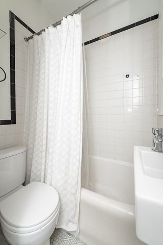 a white toilet sitting next to a bath tub